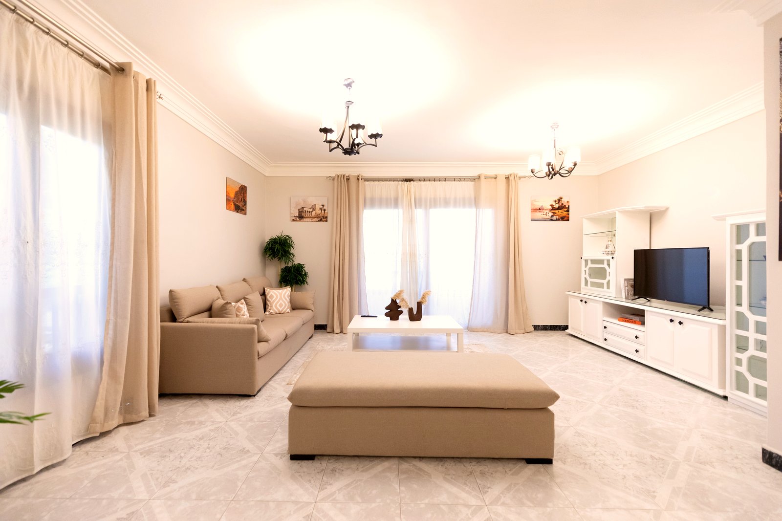 Bright living room with chandelier and wall-mounted TV